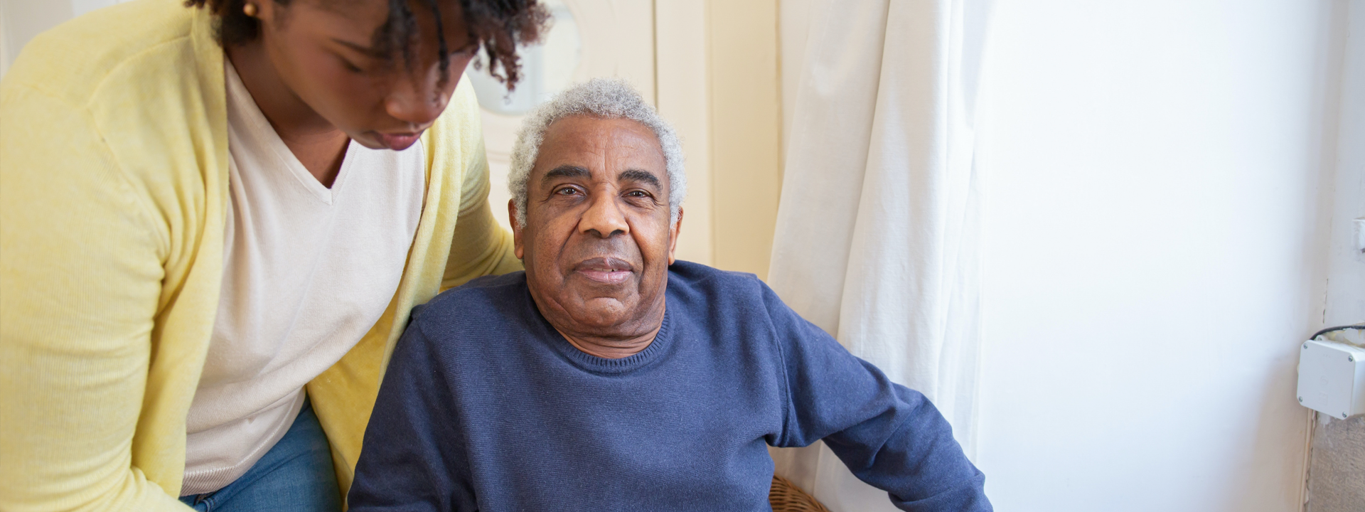 Photo showing a carer helping an elderly man